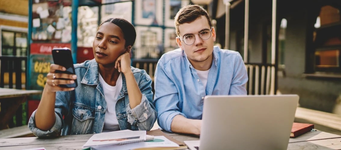 two young doctors sit outside at table