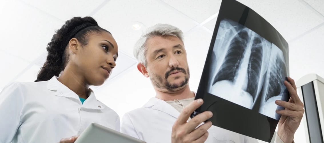 two radiologists examine the results of an x-ray