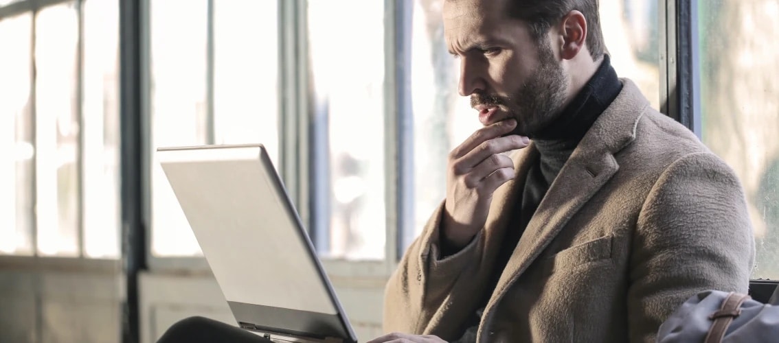 concerned male physician looking at laptop