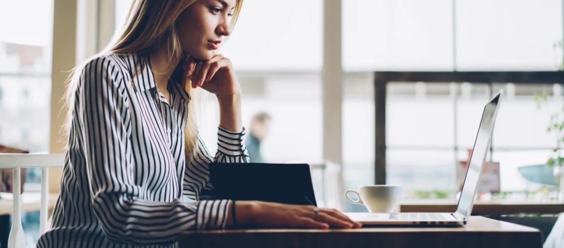 Female physician looking at laptop in a coffee shop