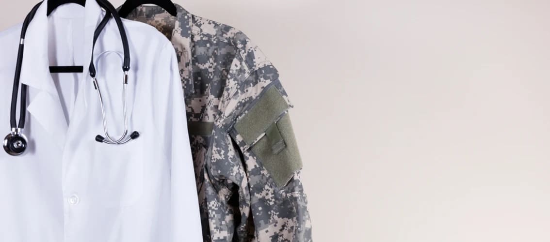doctor's white coat hangs with military uniform