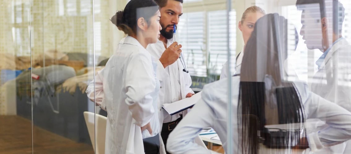 five resident physicians confer in a meeting room