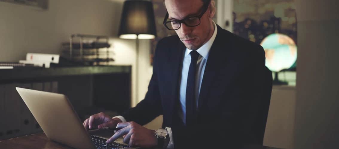 Male doctor works on his computer at night