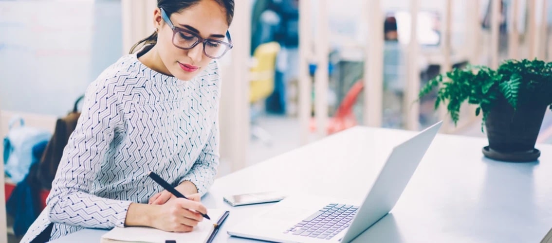 A female resident physician sits at her desk with a computer