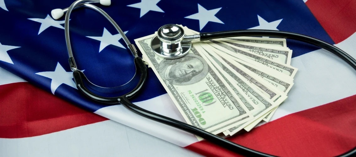 cash and a stethoscope laying on American flag