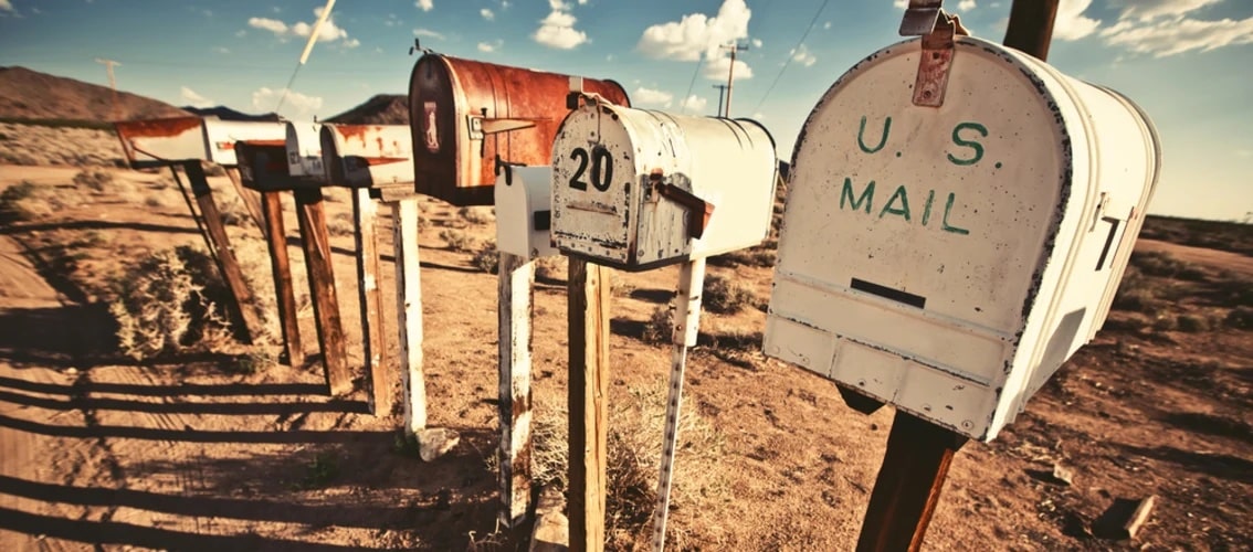 A view of rural mailboxes on a dirt road.