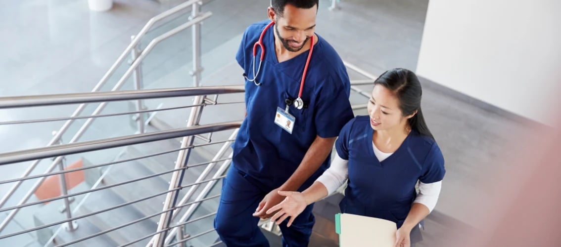 two resident physicians walking up a stair case