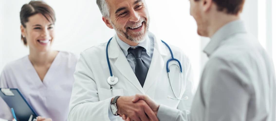 Male physician shakes hands with patient