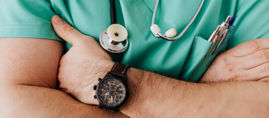 close up of a male doctors crossed arms