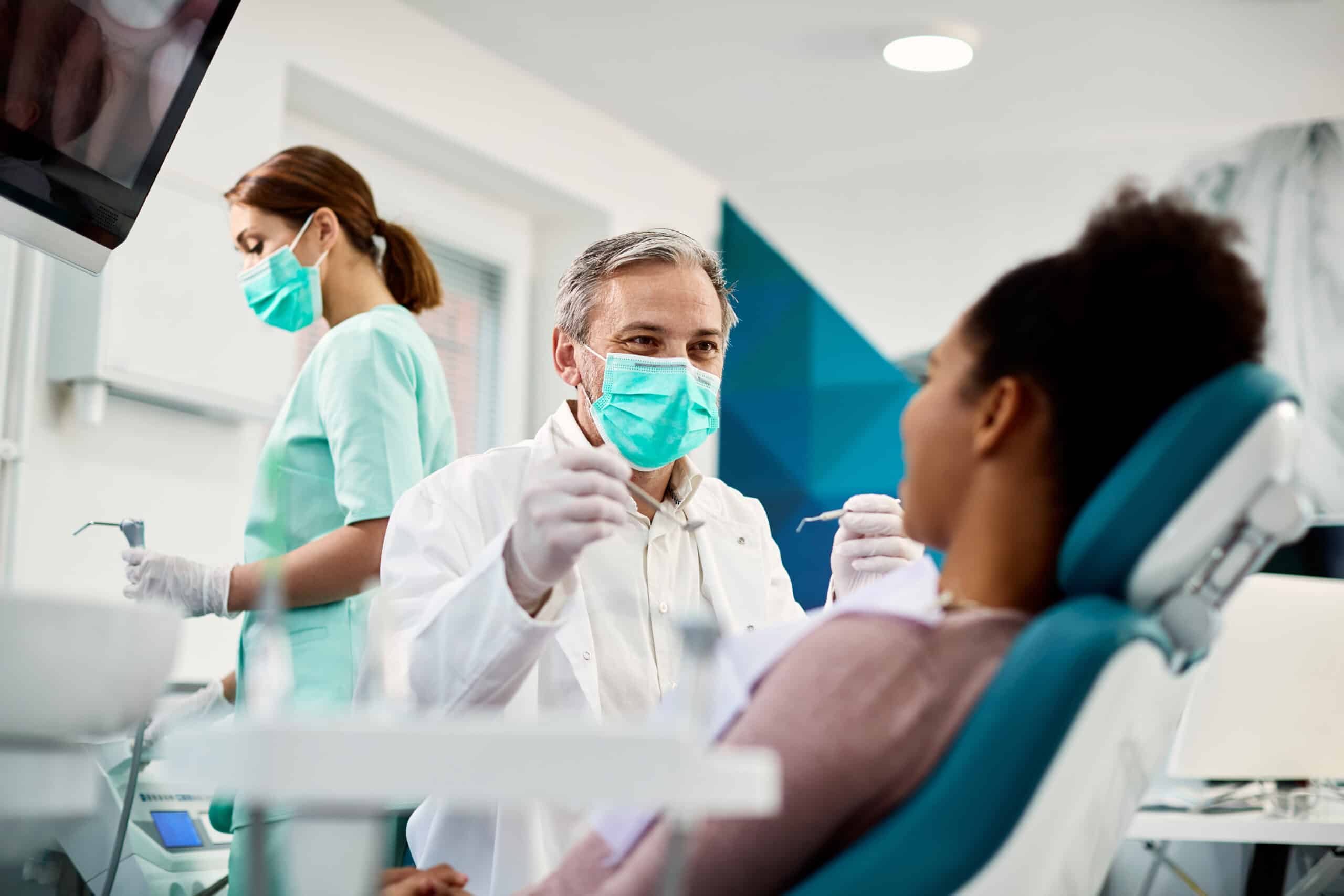 A dentist treats a patient in a dental office.