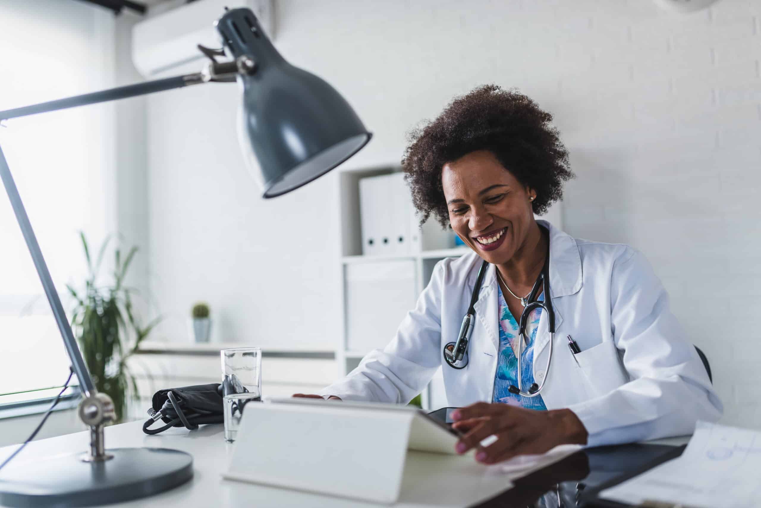 A female doctor sits in her office on the computer