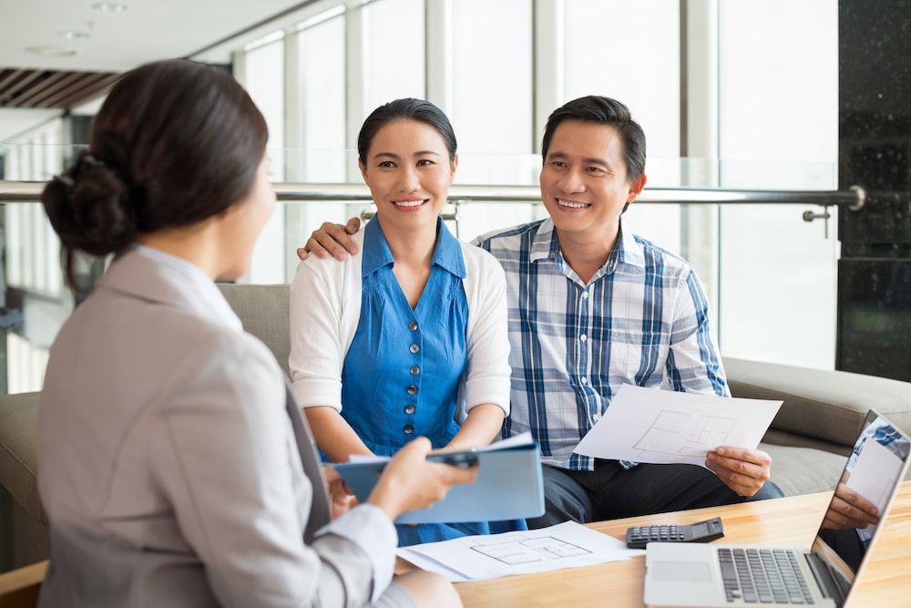 Happy physician couple meeting with a financial expert.