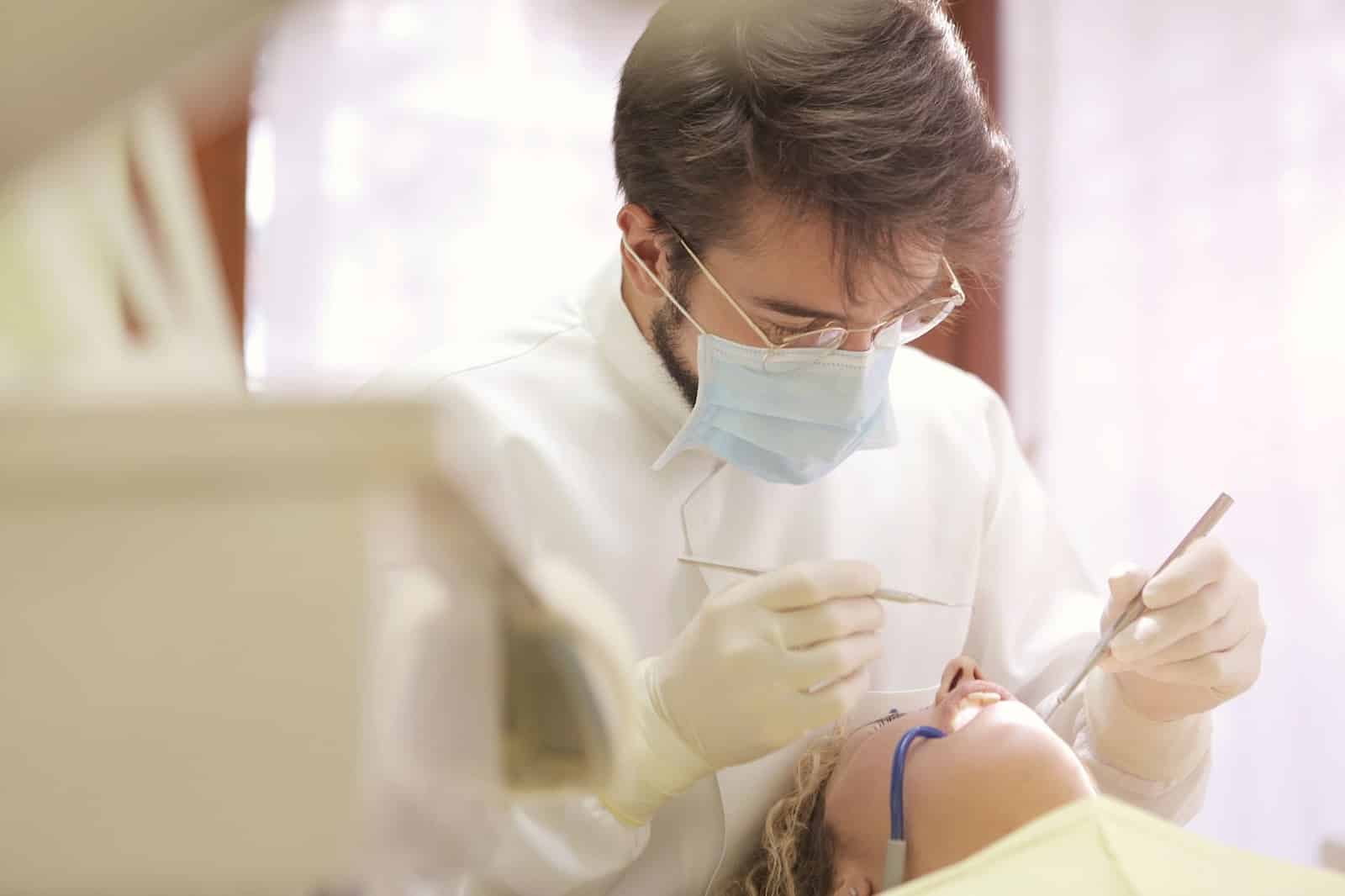 A dentist works on a reclined patient