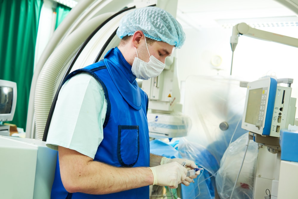 An anesthesiologist in surgery looks at his equipment.