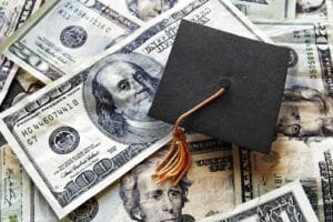 Graduation cap on pile of cash