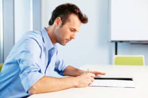 Male doctor filling out paperwork