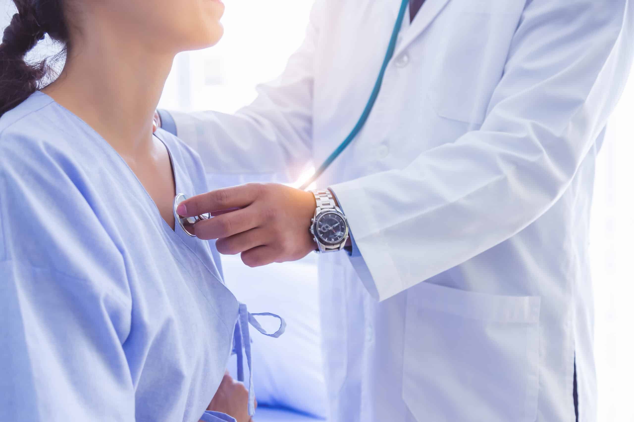 doctor using a stethoscope to check a patient's heartbeat