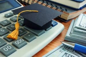 Graduation cap with calculator and cash