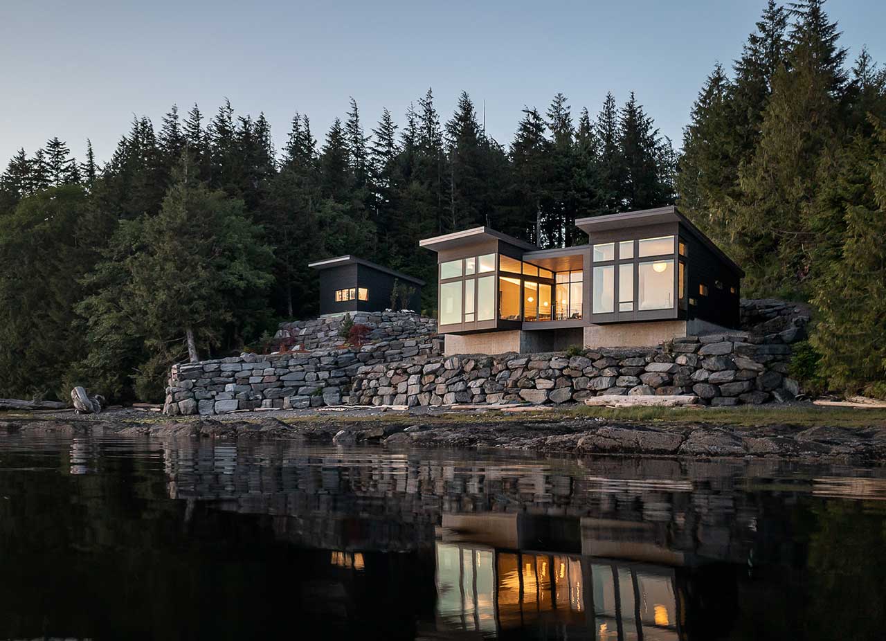 A home on the water in Alaska, built on a large stone foundation.
