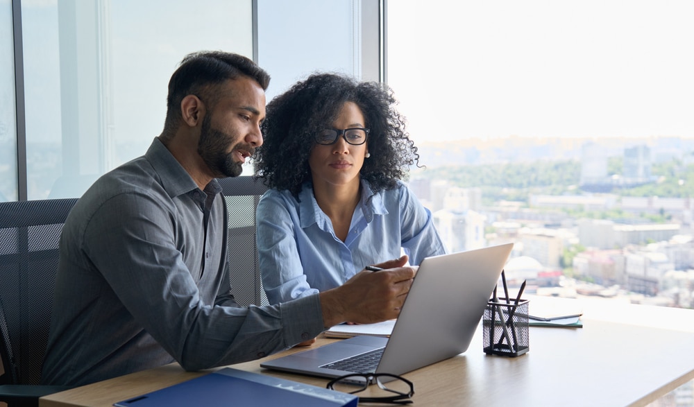 Man and woman consulting about a medical practice loan on a laptop