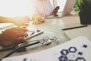 doctors working on laptops, researching moonlighting