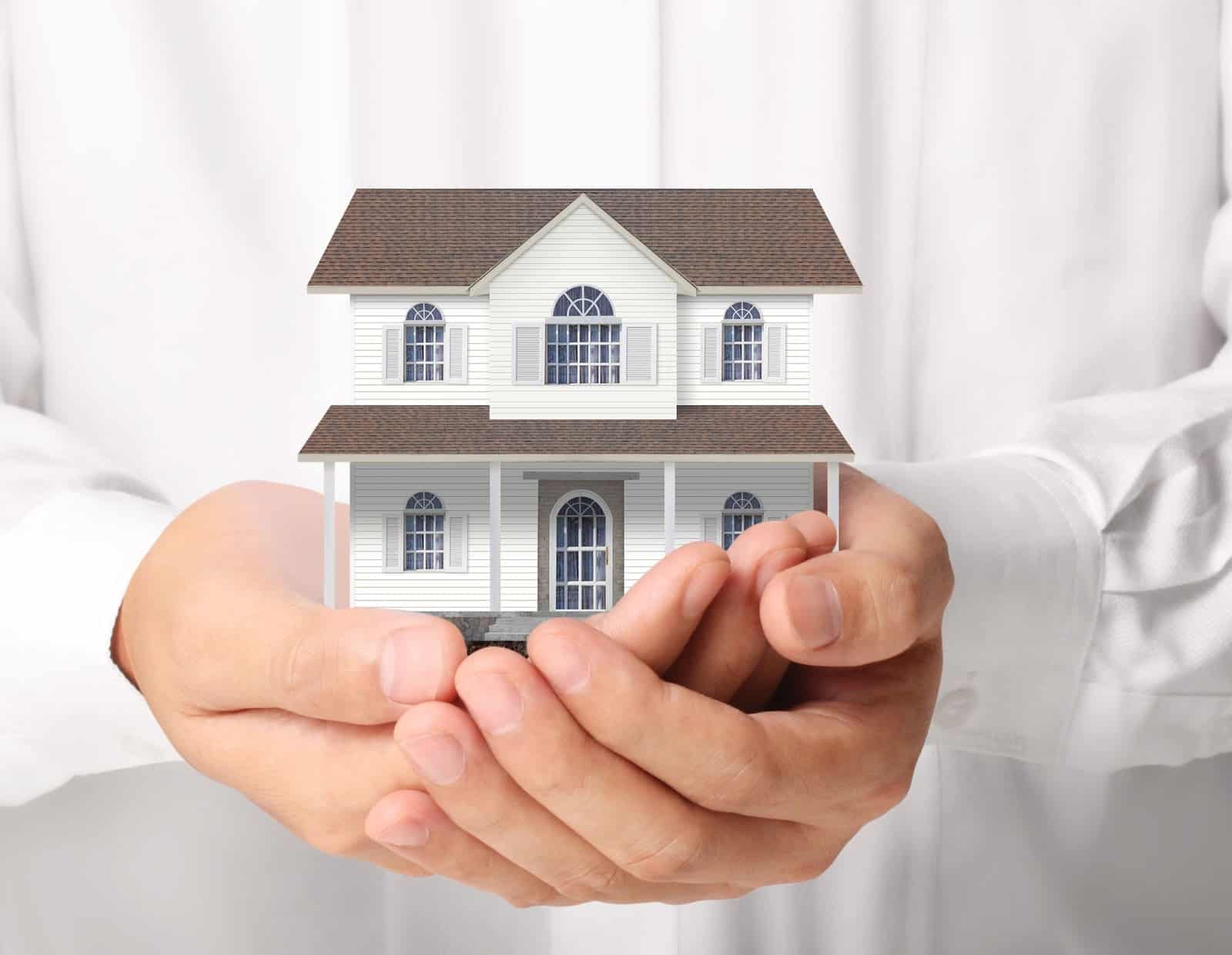 doctor holds a small model of a home