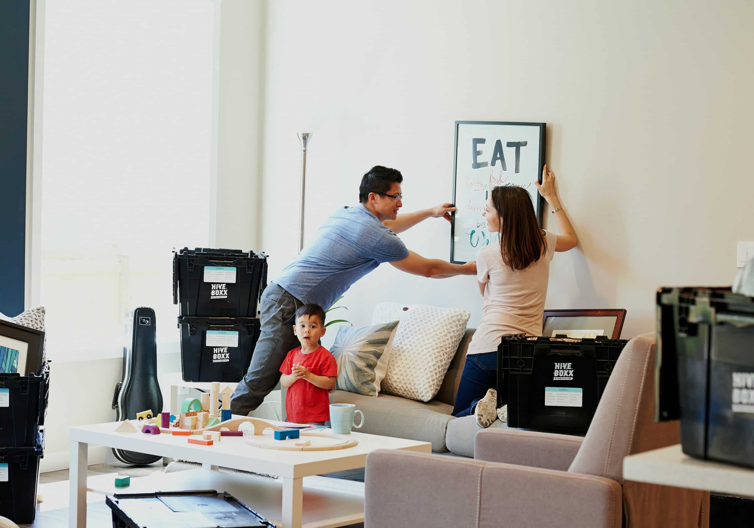 couple hangs a picture in their new home