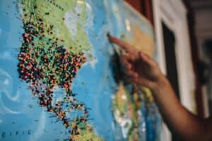 A world map with many pins stuck in it