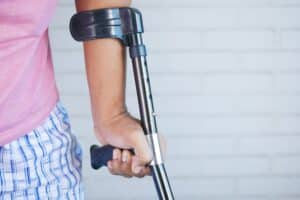 Close-up of a man's hand using a crutch/walking cane