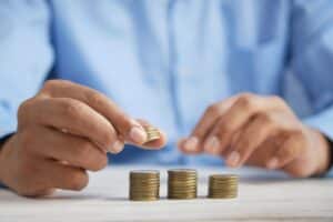 man's hands stacking coins on table